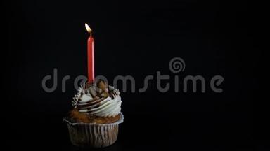 生日会盛宴庆祝理念.. 一个黑蜡烛的纸杯蛋糕。 在纸杯蛋糕上吹蜡烛。 慢慢